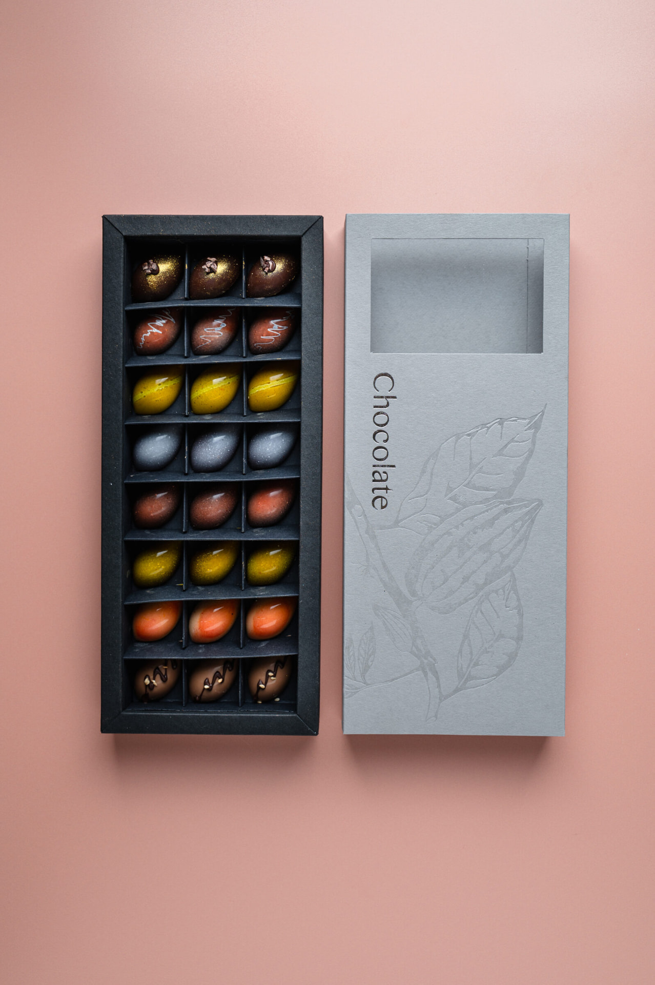 Geopende doos handgemaakte bonbons met deksel ernaast