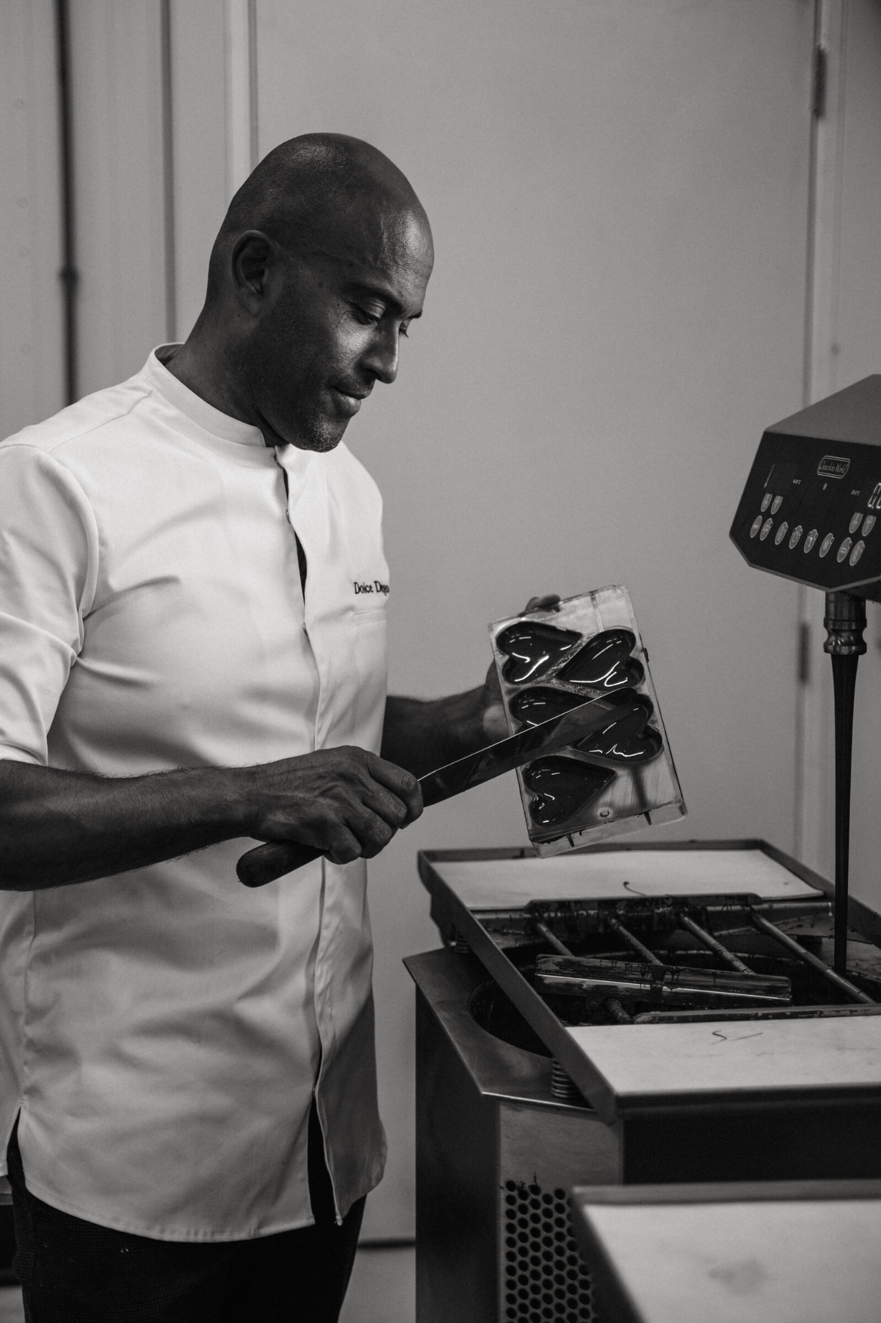 Alberto vult een chocoladevorm in zijn atelier, zwart-wit