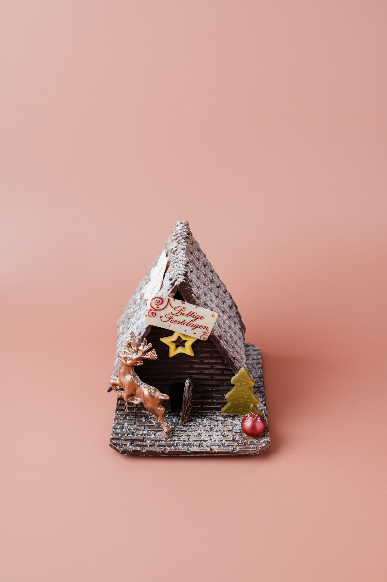 Chocoladehuisje met rendier en feestelijke decoratie